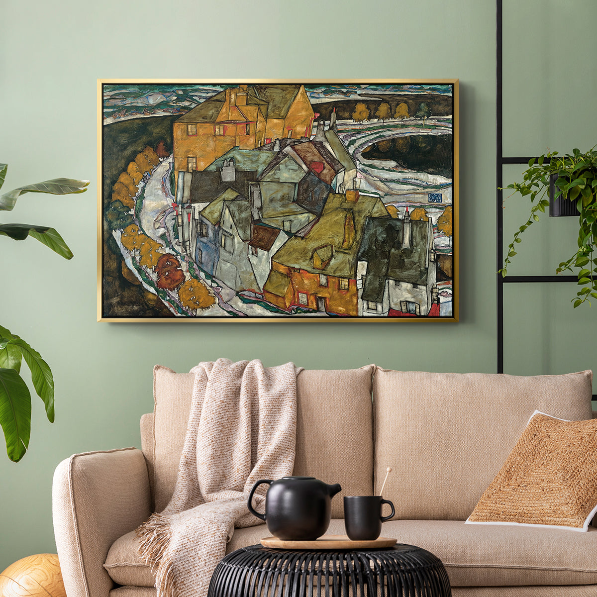 Gold floater framed canvas featuring an architectural scene with houses arranged in curved composition, displayed above a sofa in a modern living room.