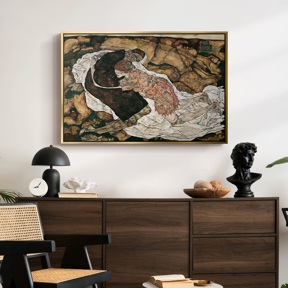 Death and the Maiden, 1915 by Egon Schiele displayed in a gold floater framed canvas above a dark wood credenza in an entryway.
