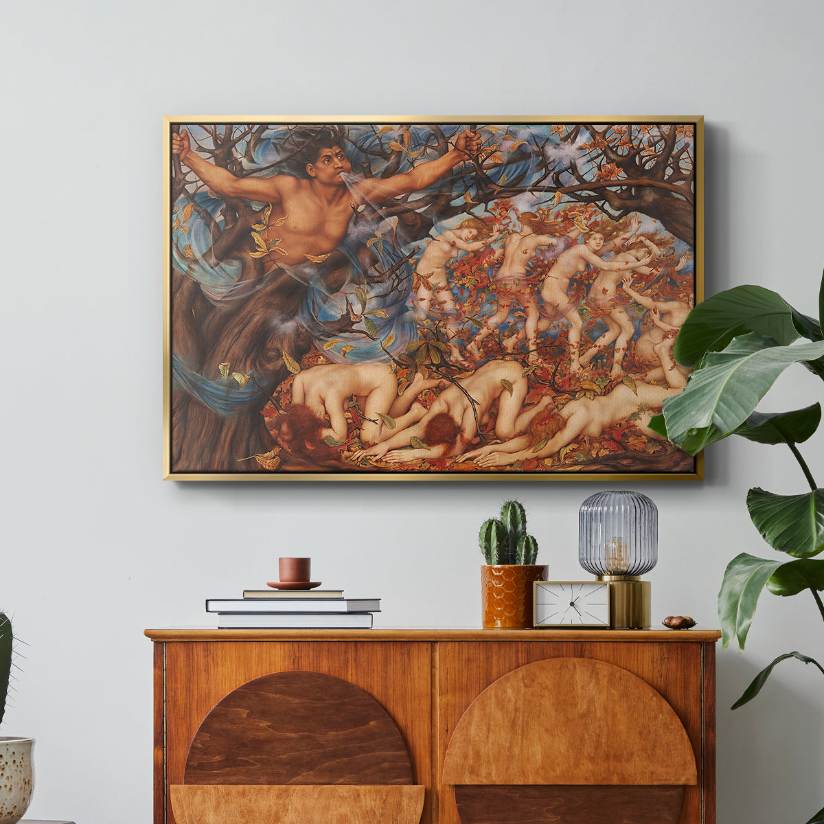Boreas and the Fallen Leaves, c. 1910-1914 by Evelyn De Morgan in a gold floater framed canvas featuring swirling figures carried by wind among falling leaves in dynamic composition, displayed above a wood console cabinet.