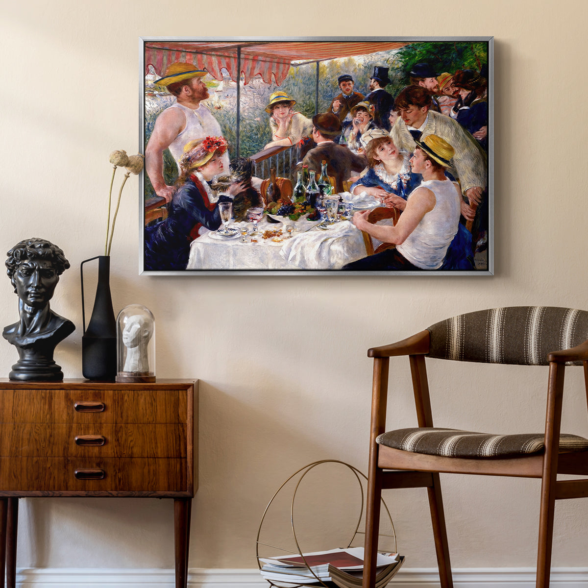 Luncheon of the Boating Party (Le Déjeuner des canotiers), 1880-1881 by Pierre-Auguste Renoir as a silver floater framed canvas featuring an impressionist scene of friends enjoying lunch with wine and conversation, styled above a mid-century console in a contemporary living area.