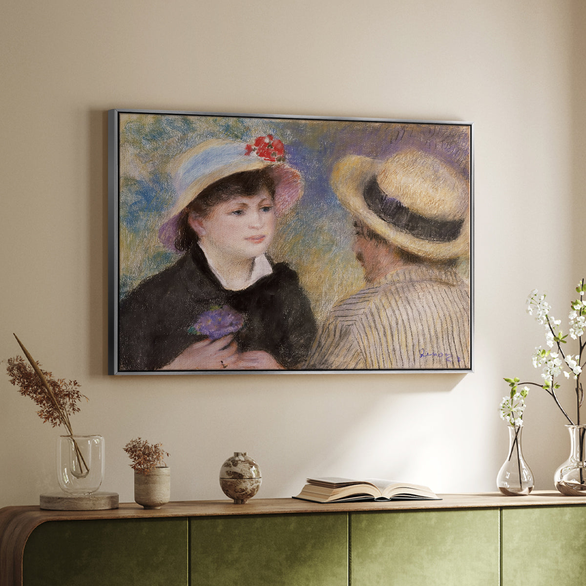 Silver floater framed canvas of Boating Couple (Aline Charigot and Renoir), c. 1881 by Pierre-Auguste Renoir, featuring an intimate portrait of man and woman sitting side by side in outdoor setting above a sideboard in a softly lit hallway.