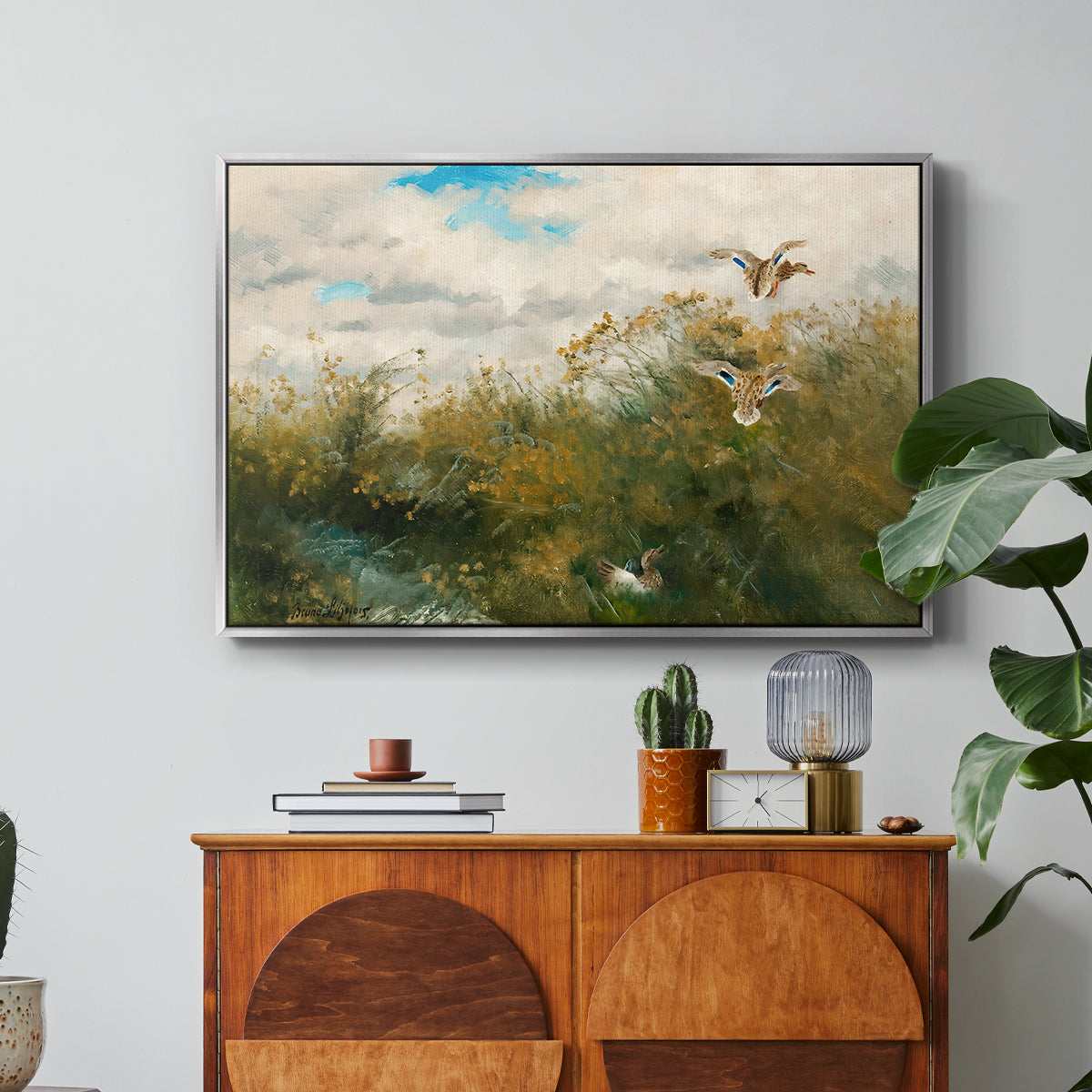 Wild Ducks (Grasänder), 1890 by Bruno Liljefors in a silver floater framed canvas featuring ducks moving through grassy wetland near water's edge, displayed above a wood console cabinet.