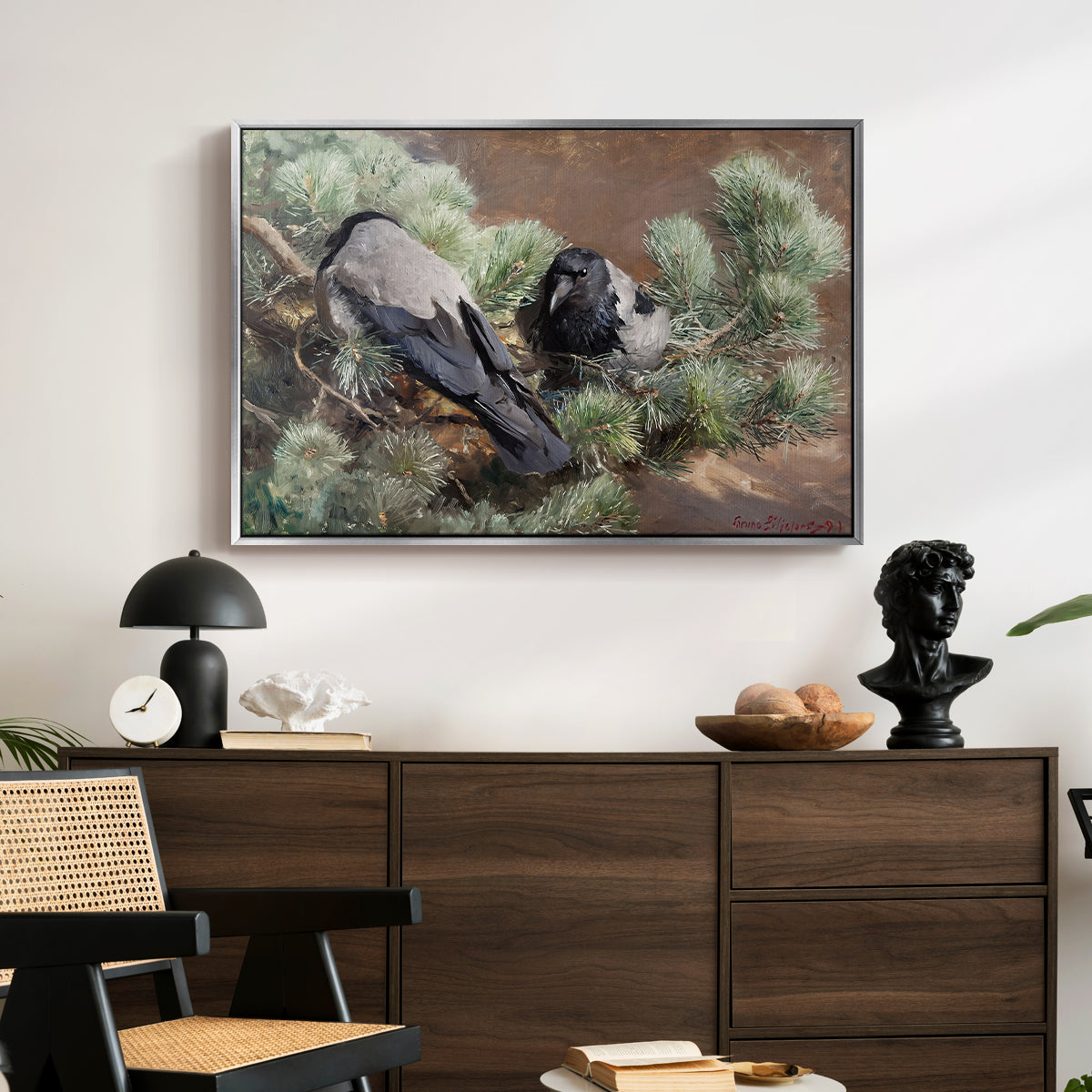 Hooded Crows (Kråkor), 1891 by Bruno Liljefors displayed in a silver floater framed canvas above a dark wood credenza in an entryway.