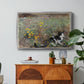 Cat on a Flowery Meadow, 1887 by Bruno Liljefors in a silver floater framed canvas featuring a cat crouching in a meadow filled with wildflowers and greenery, displayed above a wood console cabinet.