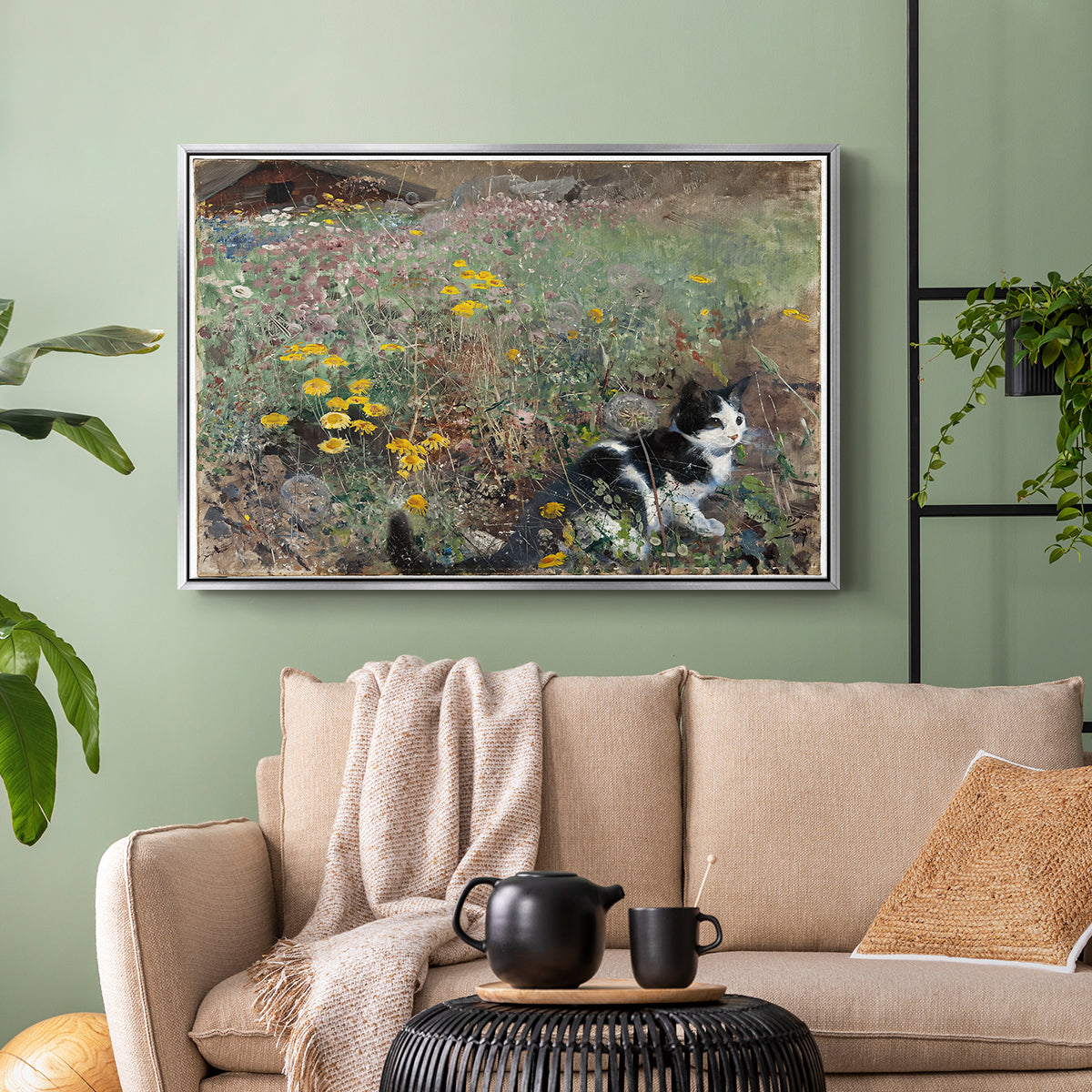 Silver floater framed canvas featuring a naturalistic depiction of cat in blooming countryside setting, displayed above a sofa in a modern living room.