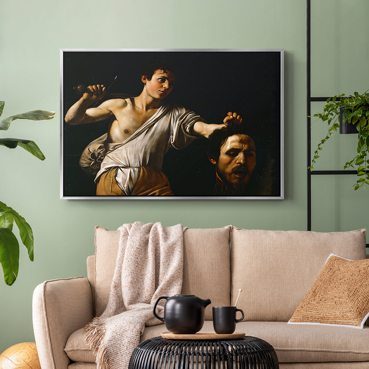 Silver floater framed canvas featuring an intense religious scene with figure emerging from darkness holding trophy, displayed above a sofa in a modern living room.