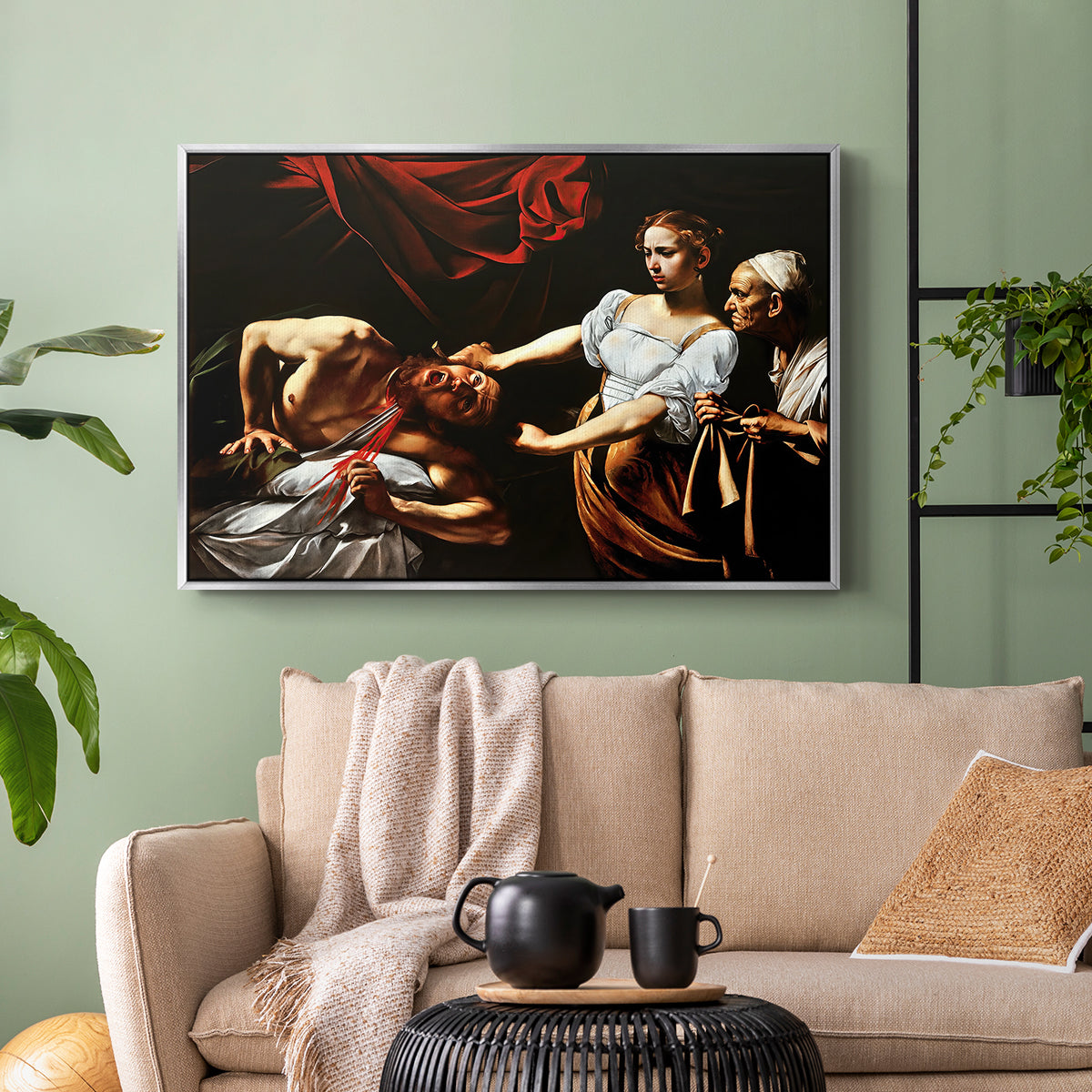Silver floater framed canvas featuring a violent religious narrative with strong contrast of light and shadow, displayed above a sofa in a modern living room.