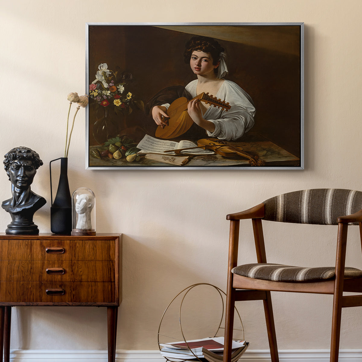 The Lute Player (Hermitage Version), c. 1596 by Caravaggio as a silver floater framed canvas featuring an intimate musical scene with instrument and decorative objects, styled above a mid-century console in a contemporary living area.