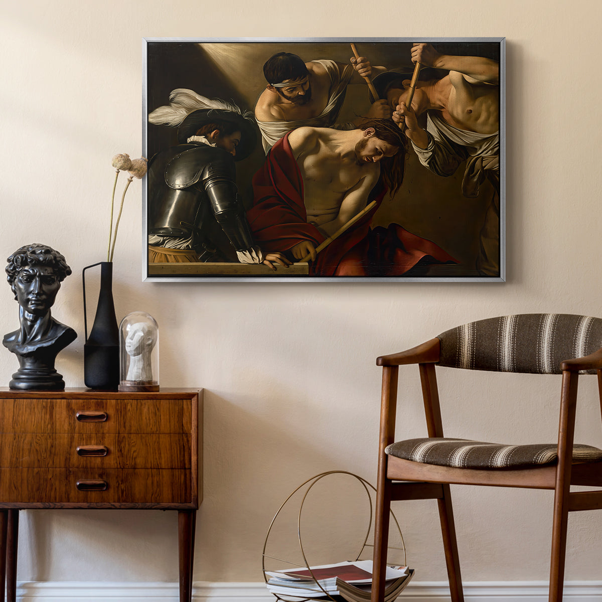 The Crowning with Thorns (Vienna Version), c. 1602-1604 by Caravaggio as a silver floater framed canvas featuring a dramatic depiction of figures forcing thorn crown onto Christ, styled above a mid-century console in a contemporary living area.