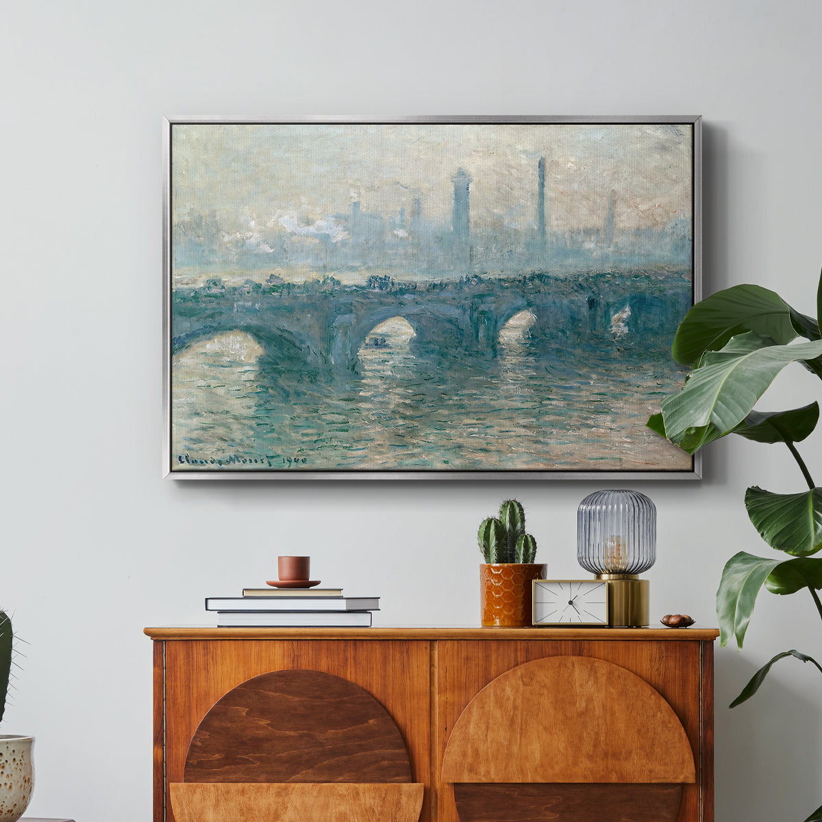 Waterloo Bridge, Gray Weather, 1900 by Claude Monet in a silver floater framed canvas featuring a hazy view of Waterloo Bridge over river in gray atmospheric light, displayed above a wood console cabinet.