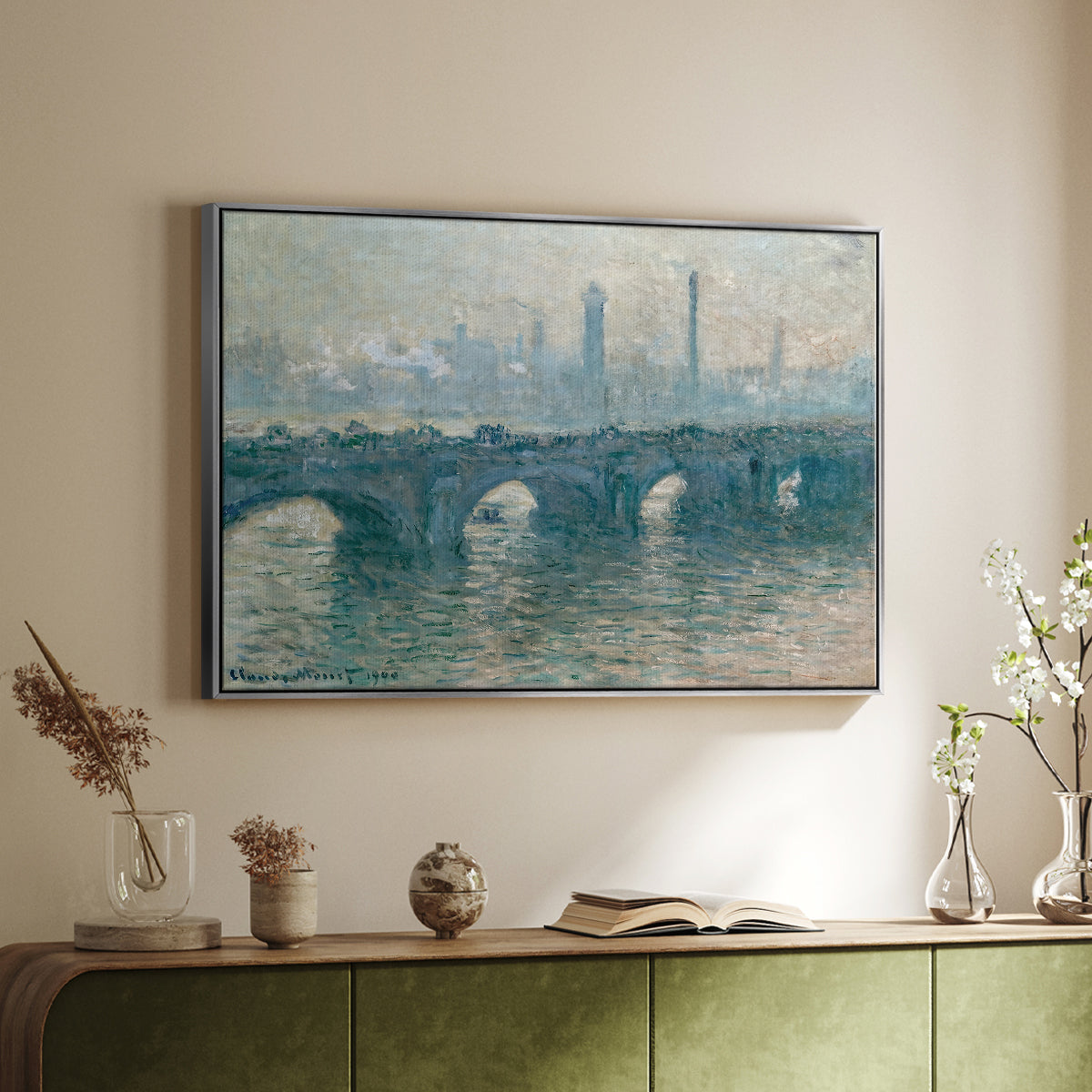 Silver floater framed canvas of Waterloo Bridge, Gray Weather, 1900 by Claude Monet, featuring an impressionist cityscape with bridge fading into fog over water above a sideboard in a softly lit hallway.
