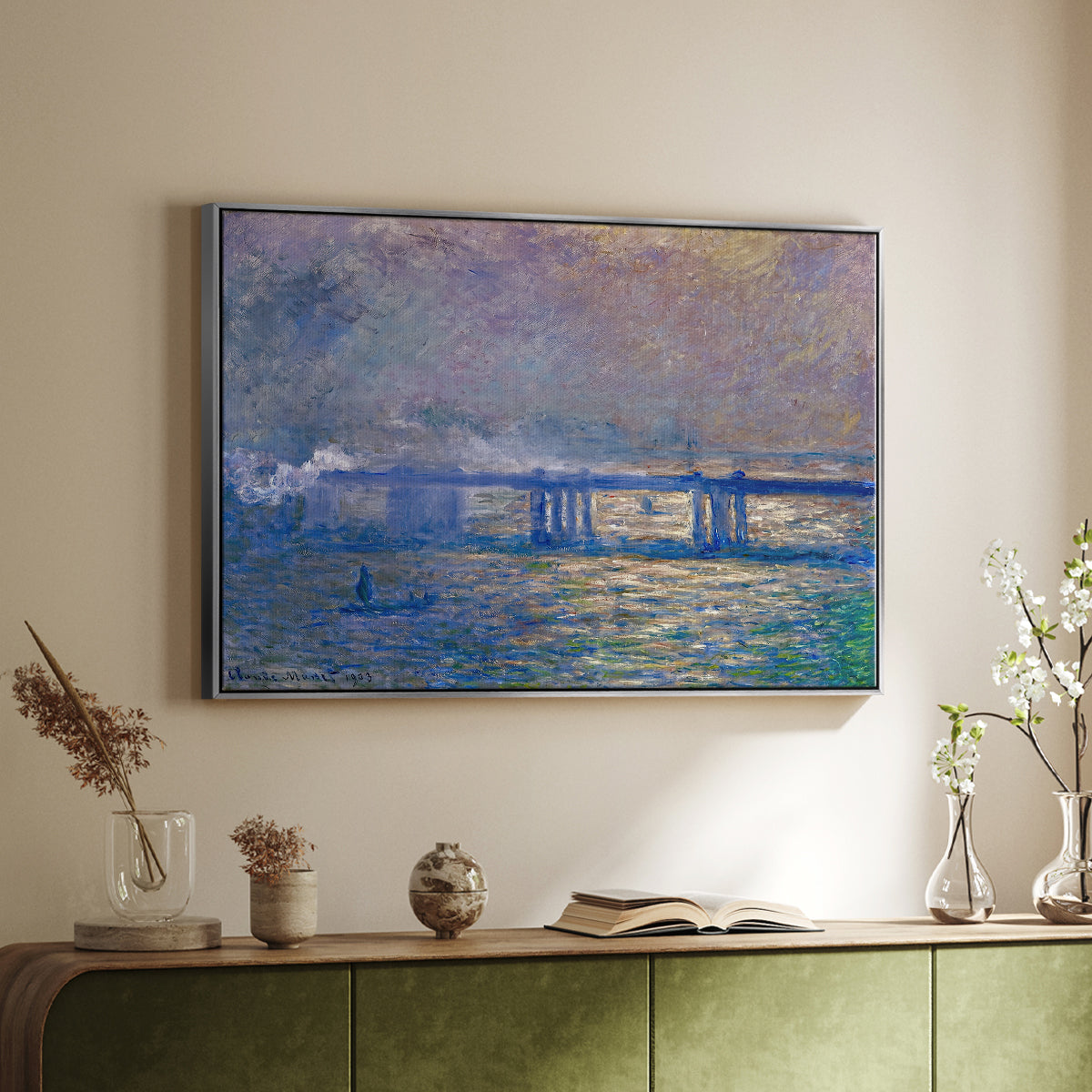 Silver floater framed canvas of Charing Cross Bridge, 1903 by Claude Monet, featuring an urban landscape with bridge and water rendered in blurred tones above a sideboard in a softly lit hallway.