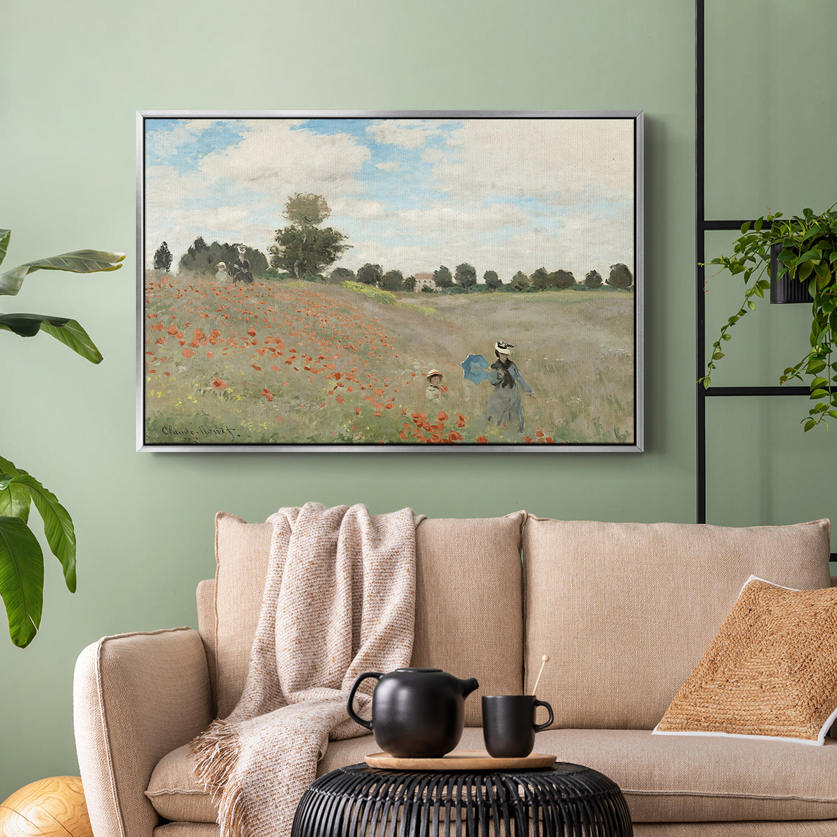 Silver floater framed canvas featuring a rural landscape with scattered figures among blooming flowers, displayed above a sofa in a modern living room.