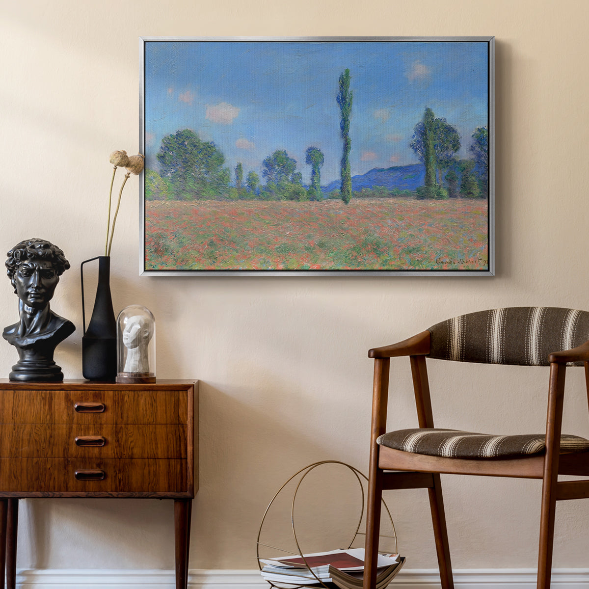 Poppy Field (Giverny), 1890-1891 by Claude Monet as a silver floater framed canvas featuring a vibrant meadow scene with flowers and vertical tree forms, styled above a mid-century console in a contemporary living area.