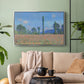 Silver floater framed canvas featuring a rural field filled with red blossoms beneath open sky, displayed above a sofa in a modern living room.