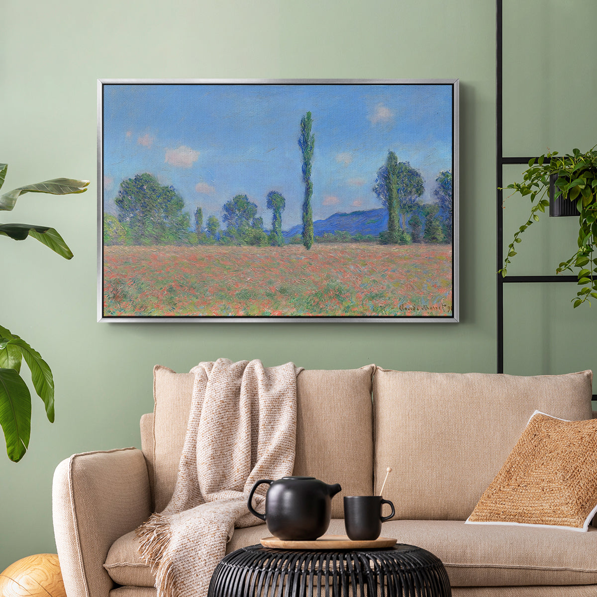 Silver floater framed canvas featuring a rural field filled with red blossoms beneath open sky, displayed above a sofa in a modern living room.