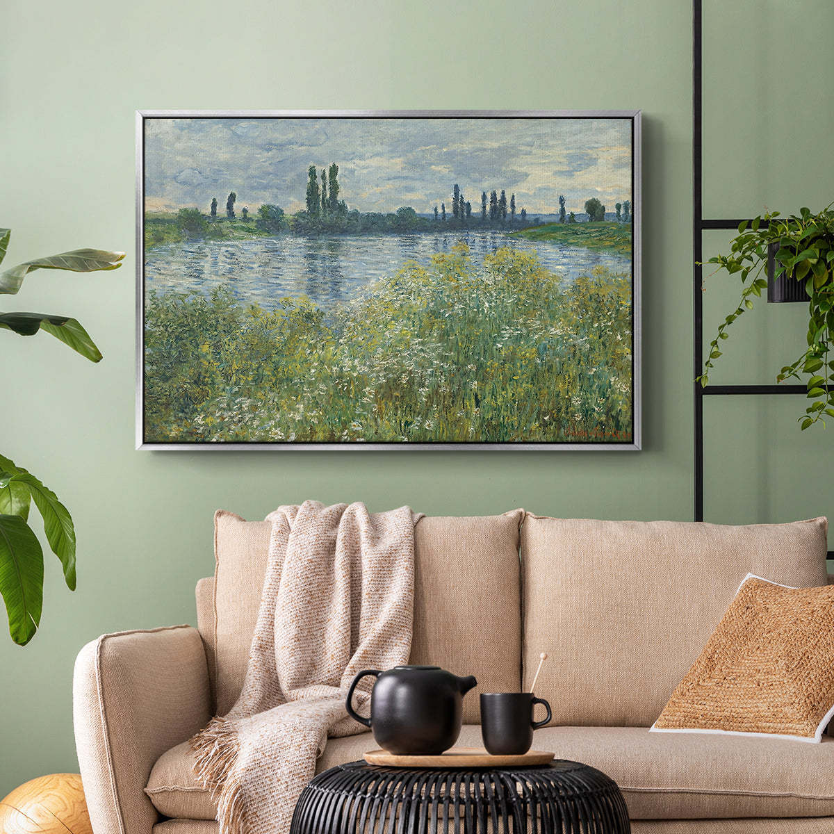 Silver floater framed canvas featuring a natural landscape with calm water and soft foliage, displayed above a sofa in a modern living room.