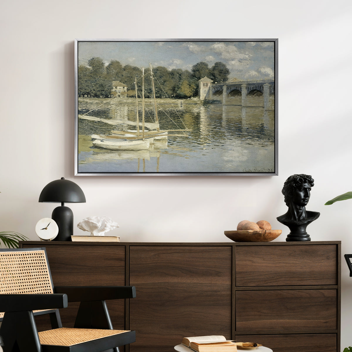 The Bridge at Argenteuil, 1874 by Claude Monet displayed in a silver floater framed canvas above a dark wood credenza in an entryway.