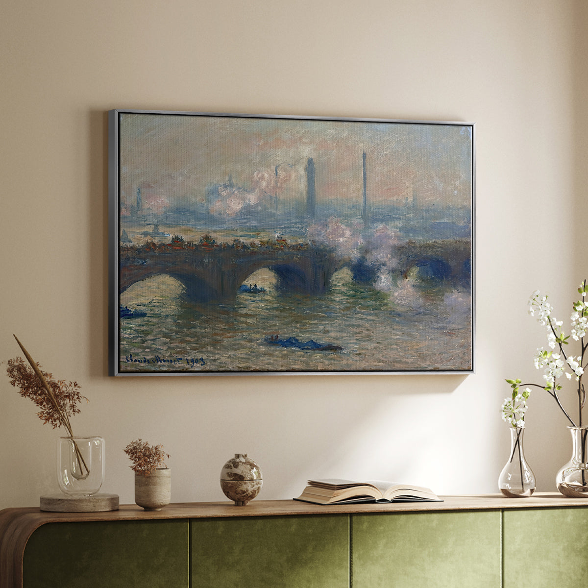 Silver floater framed canvas of Waterloo Bridge, Gray Day, 1903 by Claude Monet, featuring an impressionist depiction of bridge with soft gray tones and haze above a sideboard in a softly lit hallway.