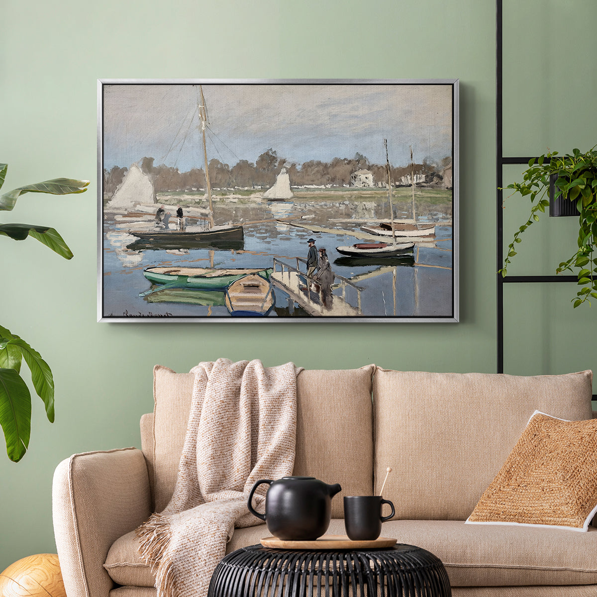 Silver floater framed canvas featuring a tranquil river setting with sailboats and shoreline, displayed above a sofa in a modern living room.