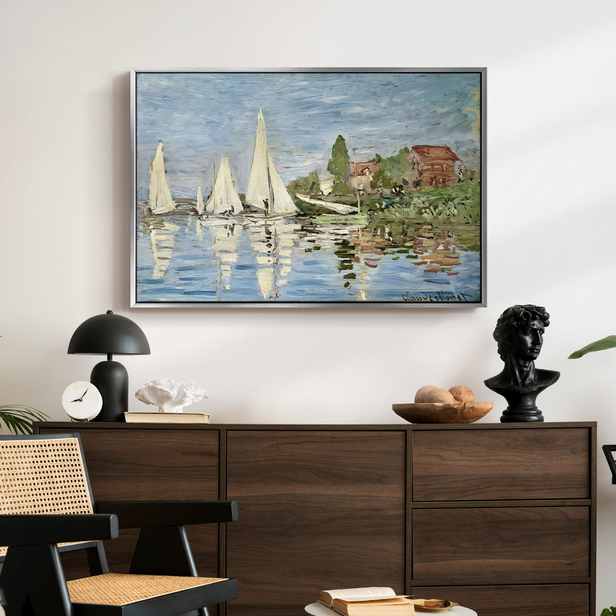 Regatta at Argenteuil, 1872 by Claude Monet displayed in a silver floater framed canvas above a dark wood credenza in an entryway.