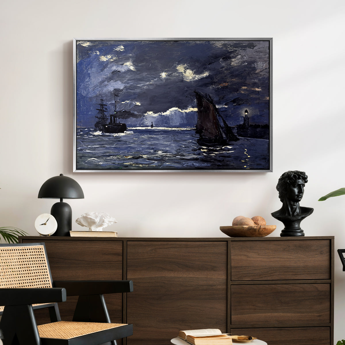 A Seascape, Shipping by Moonlight, 1864 by Claude Monet displayed in a silver floater framed canvas above a dark wood credenza in an entryway.