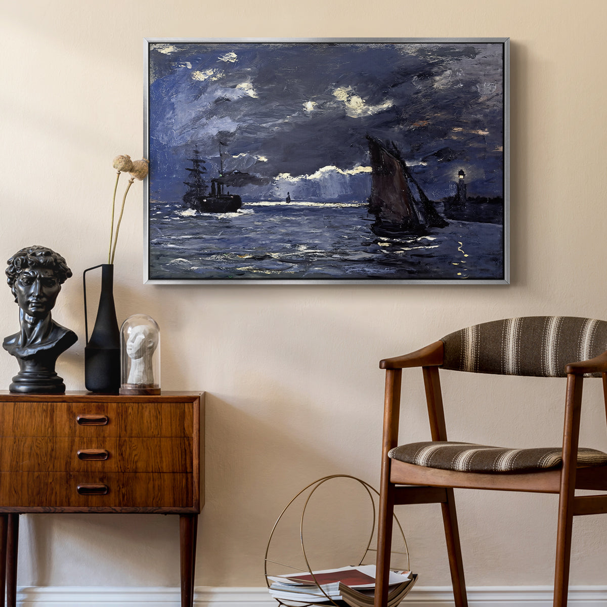 A Seascape, Shipping by Moonlight, 1864 by Claude Monet as a silver floater framed canvas featuring a dramatic ocean scene with light reflecting across water at night, styled above a mid-century console in a contemporary living area.