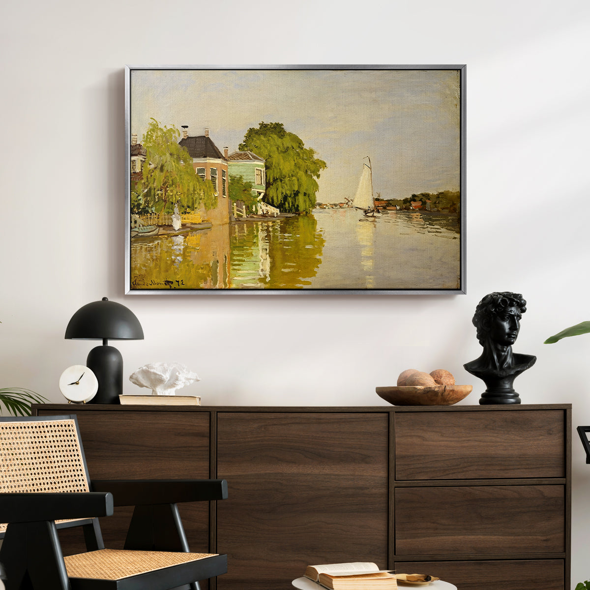 Houses on the Achterzaan, 1871 by Claude Monet displayed in a silver floater framed canvas above a dark wood credenza in an entryway.