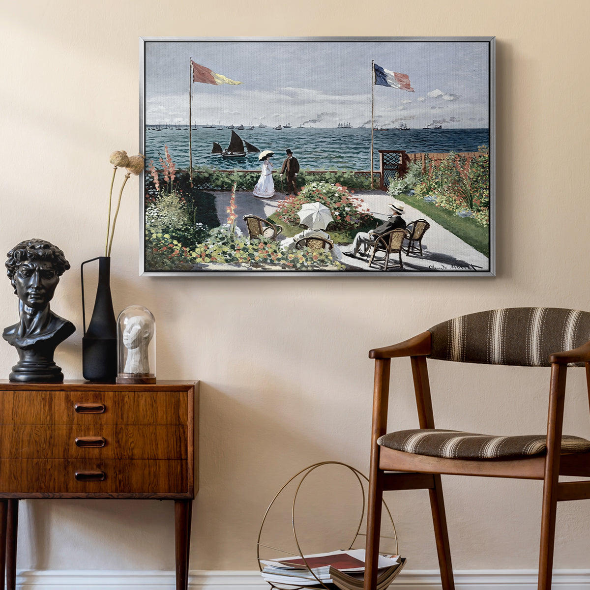 Garden at Sainte-Adresse, 1867 by Claude Monet as a silver floater framed canvas featuring a vibrant garden scene with colorful blooms and distant sea, styled above a mid-century console in a contemporary living area.