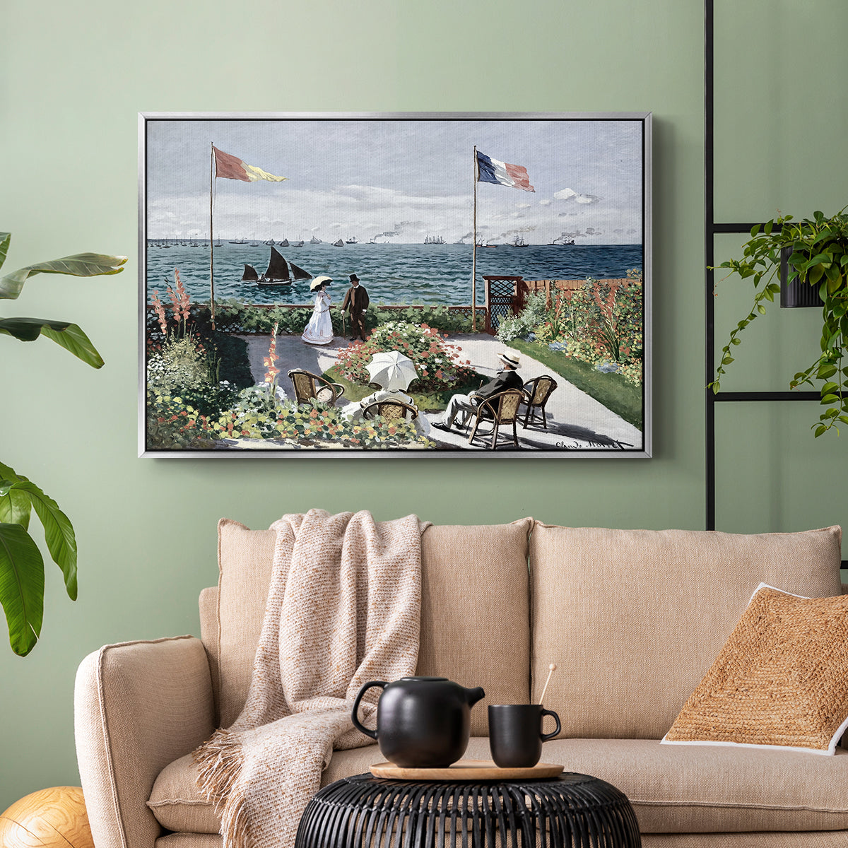 Silver floater framed canvas featuring a landscaped terrace with figures and flags near shoreline, displayed above a sofa in a modern living room.