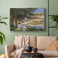 Silver floater framed canvas featuring a quiet outdoor setting with figures near river under foliage, displayed above a sofa in a modern living room.