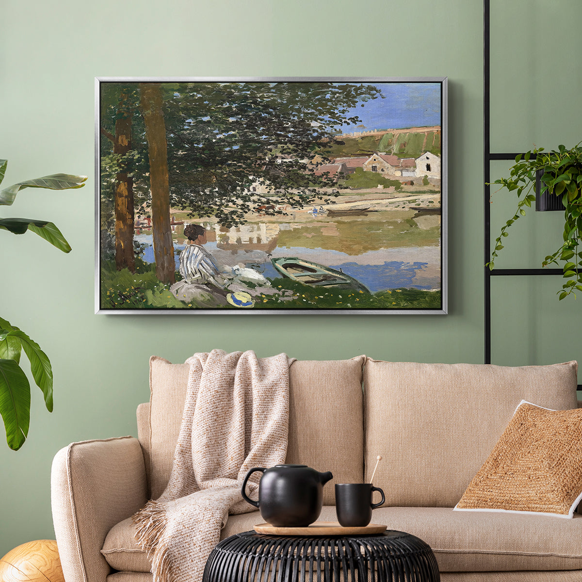 Silver floater framed canvas featuring a quiet outdoor setting with figures near river under foliage, displayed above a sofa in a modern living room.