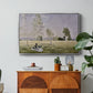 Summer (L'ete), 1874 by Claude Monet in a silver floater framed canvas featuring a woman seated in grassy field beneath tree in bright summer landscape, displayed above a wood console cabinet.