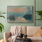 Silver floater framed canvas featuring an atmospheric landscape combining cold tones and warm sky, displayed above a sofa in a modern living room.