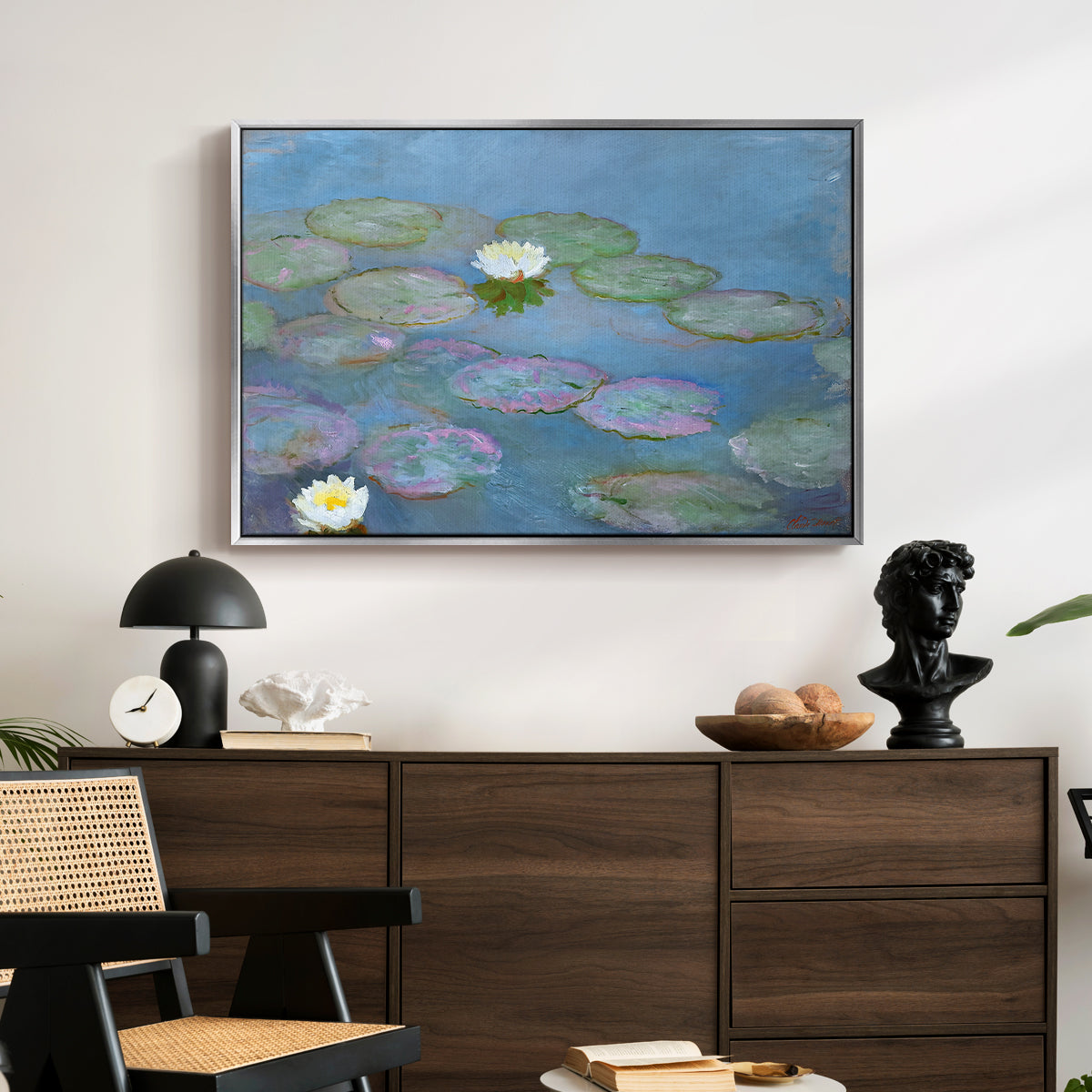 Water Lilies (Nymphéas), 1897-1899 by Claude Monet displayed in a silver floater framed canvas above a dark wood credenza in an entryway.