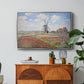 Tulip Fields with the Rijnsburg Windmill, 1886 by Claude Monet in a silver floater framed canvas featuring colorful rows of tulip fields leading toward distant windmill, displayed above a wood console cabinet.