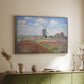 Silver floater framed canvas of Tulip Fields with the Rijnsburg Windmill, 1886 by Claude Monet, featuring a vibrant agricultural landscape with flowers and windmill above a sideboard in a softly lit hallway.
