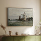Silver floater framed canvas of Windmill at Zaandam, 1871 by Claude Monet, featuring an impressionist depiction of windmill near riverbank above a sideboard in a softly lit hallway.
