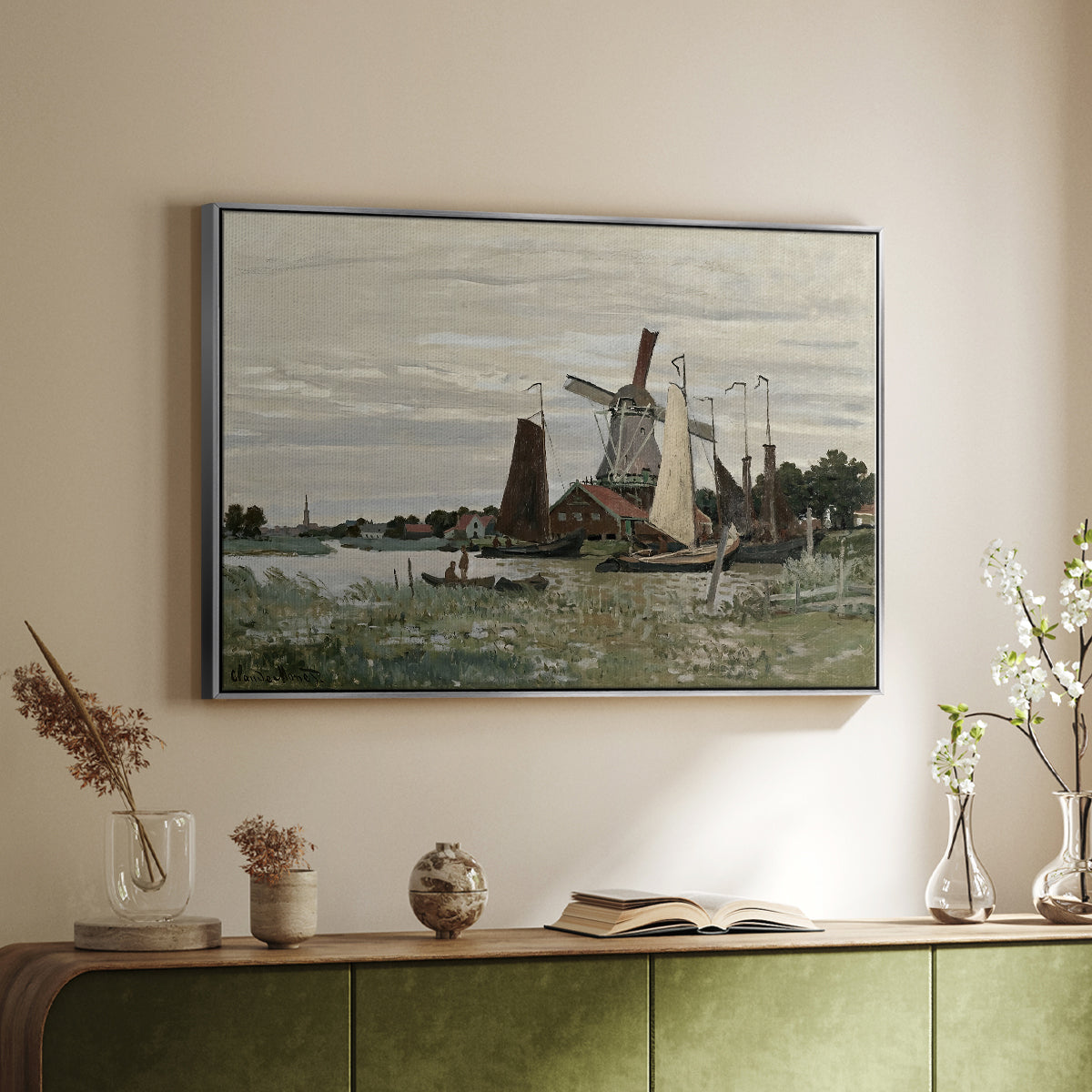 Silver floater framed canvas of Windmill at Zaandam, 1871 by Claude Monet, featuring an impressionist depiction of windmill near riverbank above a sideboard in a softly lit hallway.