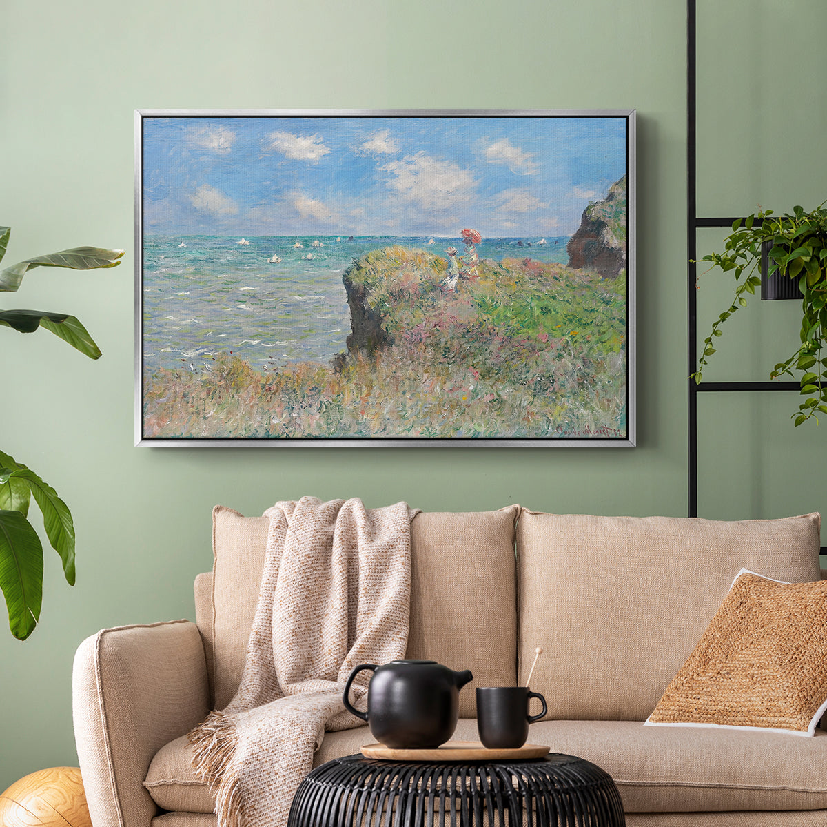 Silver floater framed canvas featuring an elevated shoreline path with figures and bright sky, displayed above a sofa in a modern living room.