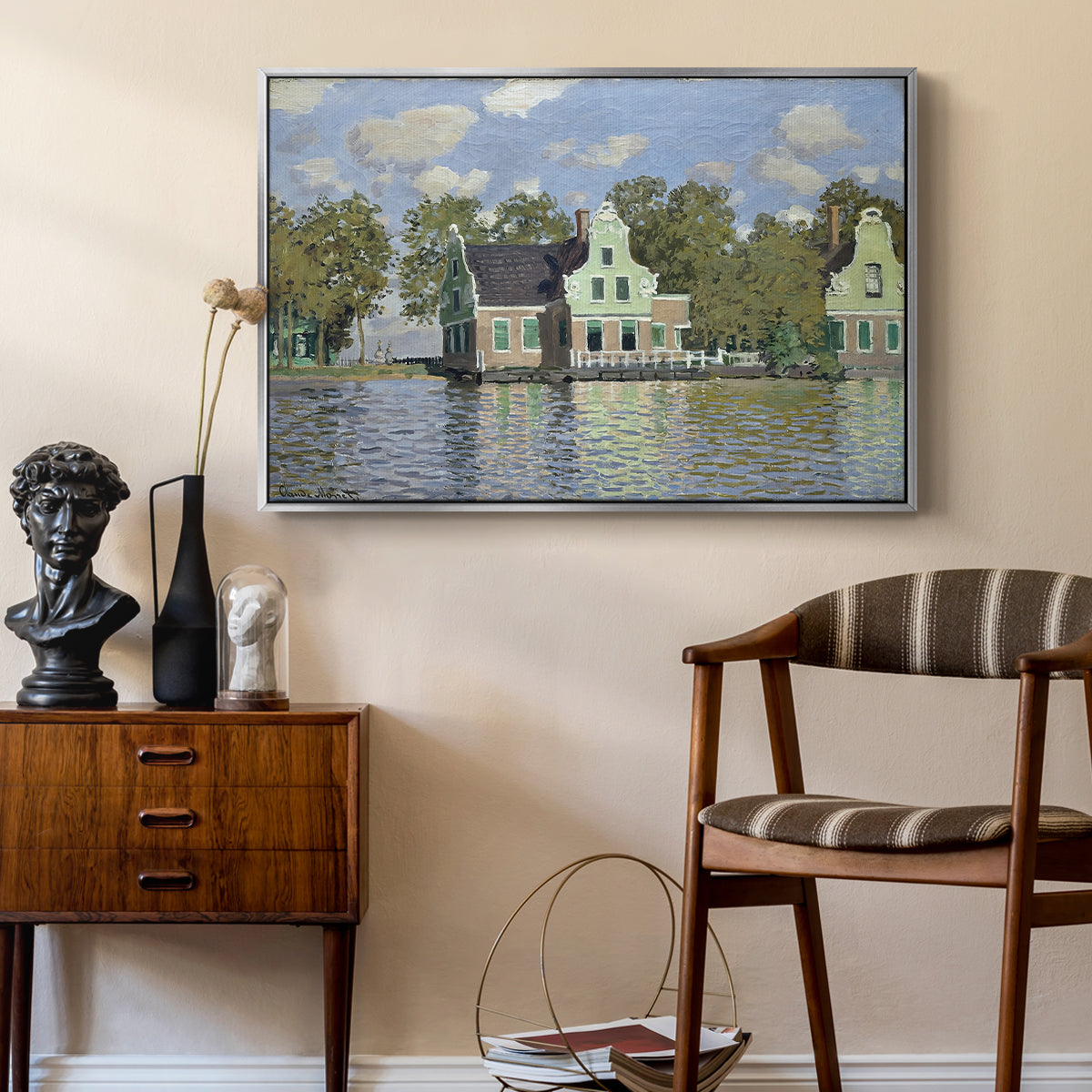 Houses on the Zaan River at Zaandam, 1871 by Claude Monet as a silver floater framed canvas featuring a peaceful canal scene with houses mirrored in water, styled above a mid-century console in a contemporary living area.