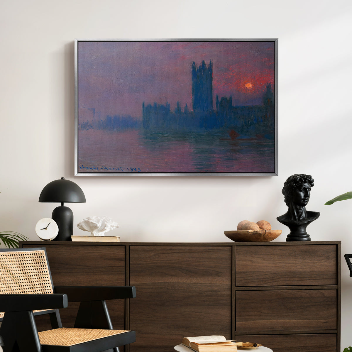 The Houses of Parliament, Sunset, 1903 by Claude Monet displayed in a silver floater framed canvas above a dark wood credenza in an entryway.