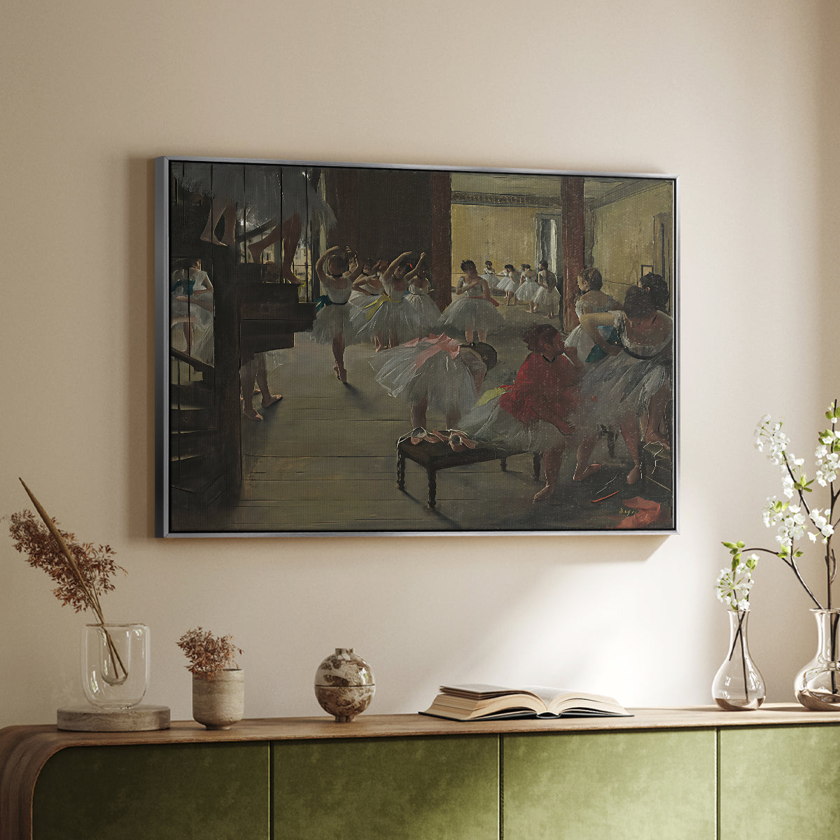 Silver floater framed canvas of The Dance Class, c. 1873 by Edgar Degas, featuring a rehearsal scene with dancers stretching and posing indoors above a sideboard in a softly lit hallway.