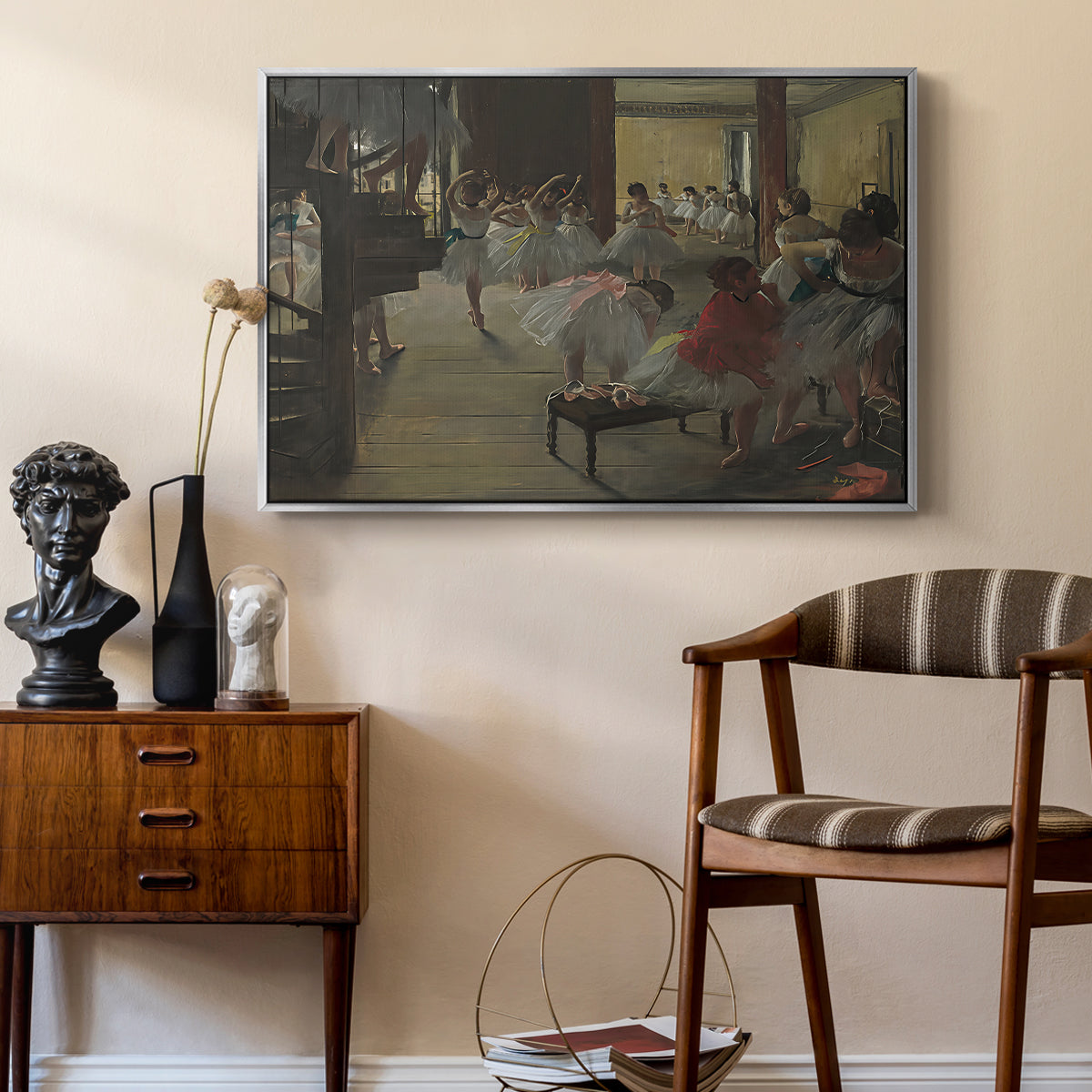 The Dance Class, c. 1873 by Edgar Degas as a silver floater framed canvas featuring an impressionist studio interior filled with ballet students, styled above a mid-century console in a contemporary living area.
