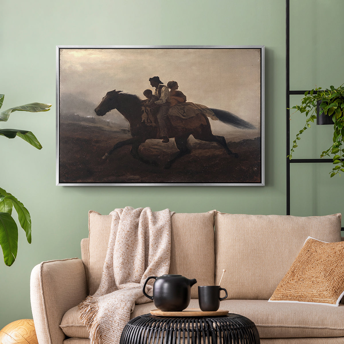 Silver floater framed canvas featuring figures on horse moving swiftly through shadowy landscape, displayed above a sofa in a modern living room.