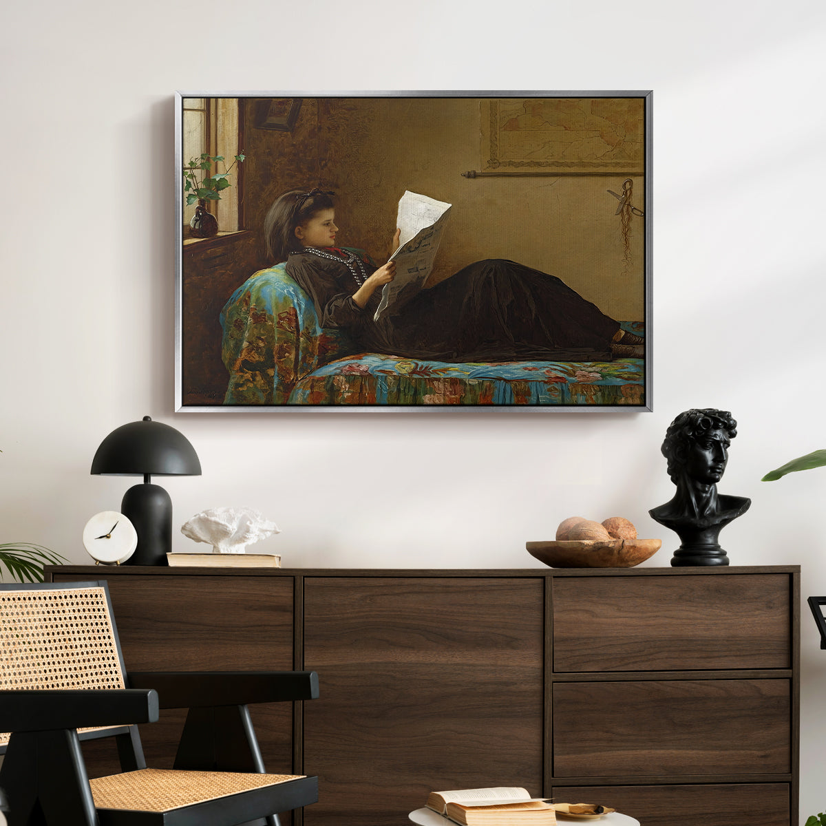 Interesting News, 1872 by Eastman Johnson displayed in a silver floater framed canvas above a dark wood credenza in an entryway.