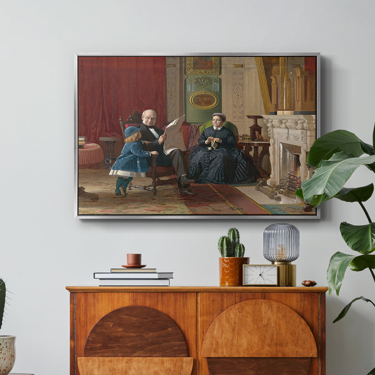The Brown Family, 1869 by Eastman Johnson in a silver floater framed canvas featuring a family seated together in interior room engaged in quiet activity, displayed above a wood console cabinet.