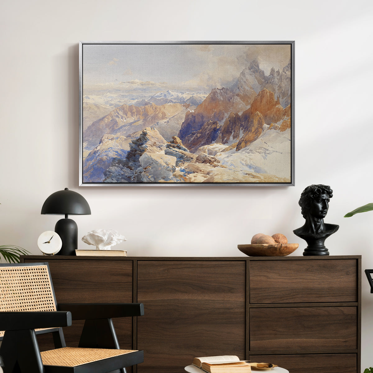 Col du Géant, 1903 by Edward Theodore Compton displayed in a silver floater framed canvas above a dark wood credenza in an entryway.