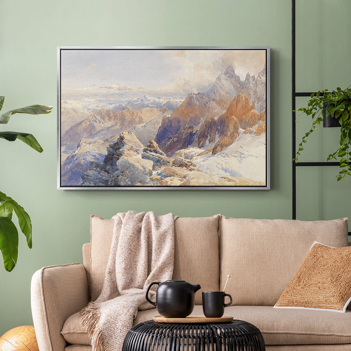 Silver floater framed canvas featuring a rugged mountain pass scene with distant peaks, displayed above a sofa in a modern living room.