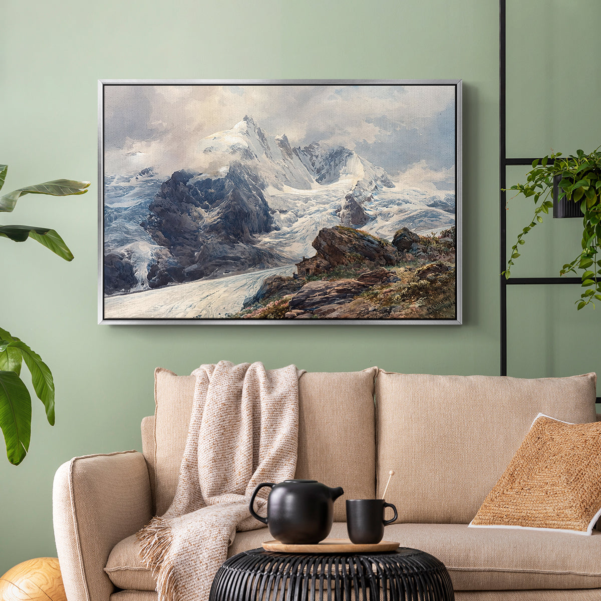 Silver floater framed canvas featuring an alpine peak dominating surrounding terrain, displayed above a sofa in a modern living room.
